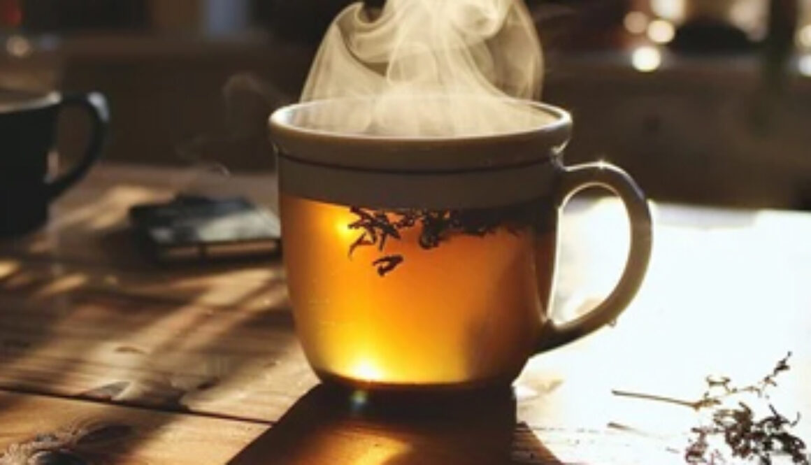 hot cup of tea, steaming on wooden table